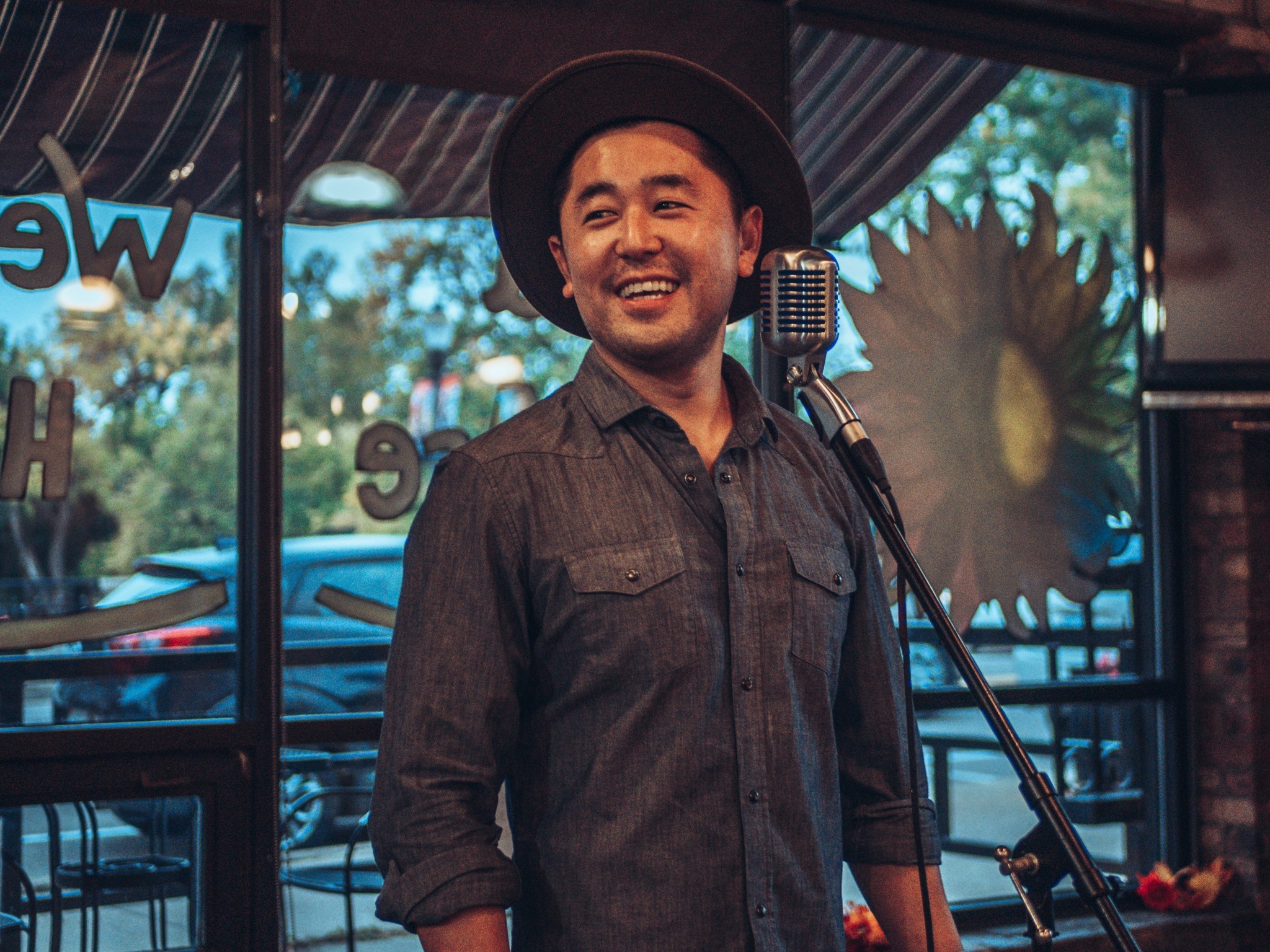 Masaki Takahashi looks to the crowd at a poetry open mic night at Sir Pizza in Old Town during the October Arts Night Out.